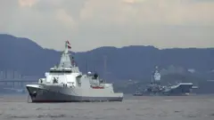 El segundo portaaviones de China, el Shandong, y el destructor de escolta Yanan están anclados después de llegar a Hong Kong, junto con un pequeño removedor.