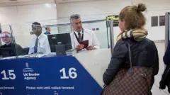 Straż Graniczna (Border Force) sprawdza paszporty pasażerów przylatujących na lotnisko Gatwick w Londynie w Anglii