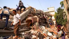 緬甸災民在大地震後於瓦礫埋中搜索生還者。