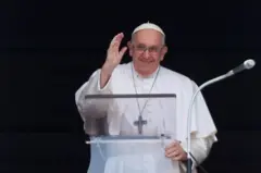 Papa Francisco de pé, sorri e acena para o público