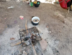Fogão improvisado sobre pedras, em área aberta