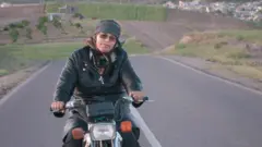 سارا شاهوردی سوار بر موتور خود در جاده.