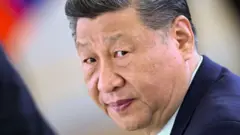 A close up photo shows Xi Jinping looking directly at the camera with a bokeh background in Moscow on 8 May.