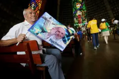 Um homem segura uma bandeira do papa Francisco dentro da Catedral Metropolitana antes da chegada do papa Francisco em 22 de julho de 2013 no Rio de Janeiro, Brasil