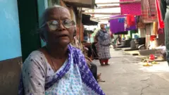 জ্যেষ্ঠ বাসিন্দা কাড়তি দেরাম্মা বলছেন, শত বছর আগে বাসস্থান দেয়ার নিশ্চয়তা দিয়েই তাদের পূর্বপুরুষদের ভারতের অন্ধ্রপ্রদেশ আর তেলেঙ্গানা থেকে এখানে নিয়ে আসা হয়েছিল।