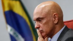 Alexandregreenbets sinaisMoraes com o dedo indicador sobre os lábios, aparentando preocupação