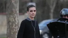 Una mujer con auriculares con cable.