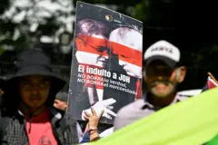 Una mujer sostiene una pancarta que dice "El indulto a Juan Orlando Hernández (JOH) no borra la verdad, no borra el narco-estado," durante una protesta convocada por el Consejo Cívico de Organizaciones Populares e Indígenas de Honduras (COPINH) y la Plataforma Agraria frente a la Embajada de EE. UU. en Tegucigalpa el 4 de diciembre de 2025. El (Foto de Orlando SIERRA / AFP vía Getty Images)