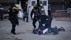 Immigration officers hols protester down sake of di demonstrations