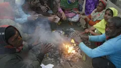 আগুন জ্বালিয়ে তাপ পোহাচ্ছেন অনেকে