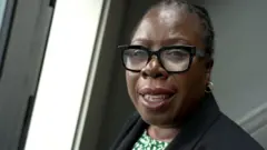 Paulette Hamilton é uma mulher negra e usa óculos