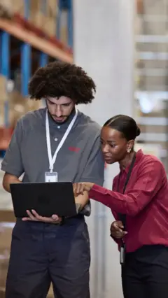 Un homme et une femme qui regarde un ordinateur portable