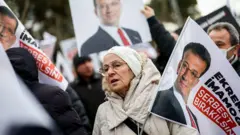 9 Mart 2026, bir kadın İmamoğlu serbest bırakılsın yazılı bayrak tutuyor, protestocularla birlikte.