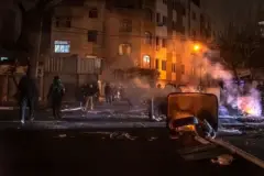 إيرانيون يتجمعون أثناء إغلاقهم أحد الشوارع خلال احتجاجات في العاصمة الإيرانية طهران، في 9 يناير/كانون الثاني 2026، ويظهر مجموعة من الشباب أثناء الليل، وأمامهم نيران مشتعلة لأحد إطارات السيارات.