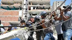 Moradores removem manualmente pedaços de concreto durante as operações de resgate