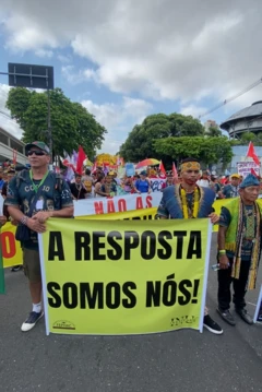 Manifestantes indígenas segurando um cartaz onde se lê "A resposta somos nós"