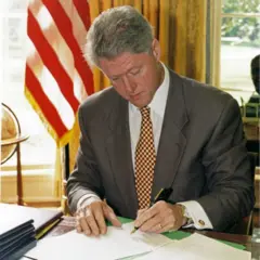 Bill Clinton assina um papel