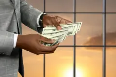 Les mains d'un homme en costume qui compte de l'argent