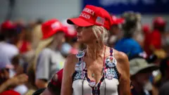 Sarışın bir kadın. Kırmızı kasketinde "Make America Great Again" yazıyor
