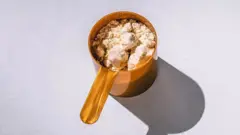 Recipiente de plástico cheio de suplemento de creatina em pó