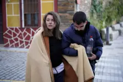 Ana, una mujer joven herida y con una manta es ayudada por otra persona.