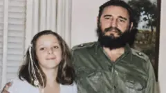 The late Cuban leader Fidel Castro, wearing a green military uniform, is seen alongside his daughter, Alina Fernandez, in a photo taken in the 1960s.