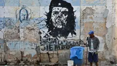 Homem em frente a cartaz de Che Guevara