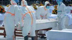 Abantu barimo guterura isanduku muri uwo muhango