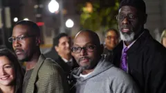 從左到右依序為阿爾弗雷德·切斯特納特、安德魯·斯圖爾特和蘭索姆·沃特金斯，他們在被宣告無罪釋放後，與攝影師合作。他們此前因1983年的謀殺案而被定罪。
