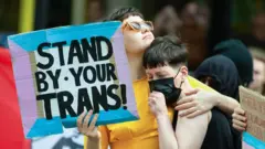 Una manifestante pro-trans sostiene una pancarta durante una manifestación en Mánchester, Reino Unido, en 2022.