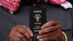 رجل يحمل جواز سفر كويتياً