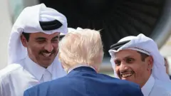 الدوحة، قطر - 15 مايو: يتحدث الرئيس الأمريكي دونالد ج. ترامب مع أمير قطر تميم بن حمد آل ثاني (يسار) ومحمد بن عبد الرحمن بن جاسم بن جابر آل ثاني (يمين)، رئيس وزراء قطر، بينما يغادر قاعدة العُديَد الجوية متوجهاً إلى أبوظبي في 15 مايو 2025، في الدوحة، قطر. 