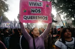 Una chica sostiene un cartel en el que dice "Vivas nos queremos" en una manifestación.