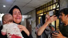 Una madre y su bebé con sangre en la ropa
