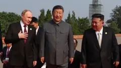 從左到右：身穿黑色西裝紅色領帶的普京、身穿灰色中山裝的習近平和身穿黑色西裝米白色領帶的金正恩並肩登上天安門城樓台階（3/9/2025）