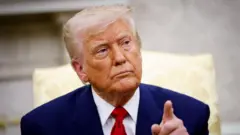 Donald Trump usa um terno azul marinho e uma gravata vermelha. Ele aponta o dedo e tem uma expressão facial séria.