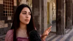 صورة لفتاة بشعر بني داكن تشير بيدها.