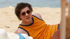 Dylan Llewellyn como Jack Rooke, deitado na praia em cena de 'Big Boys'