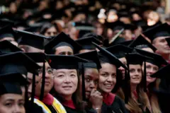 Estudiantes en toga y birrete durante ceremonia de graduación de la Universidad de Harvard