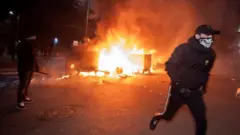 Огонь и бегущий демонстрант на улице в Софии