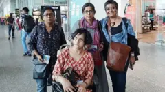 কুহু দাস (বাঁয়ে দাঁড়ানো) এবং জিজা ঘোষ (বসা) অন্যদের সাথে