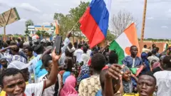 Nigeriens dey wave Russia flag