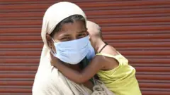 Woman and son wait for testing in Delhi