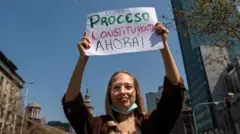 Una mujer sostiene un cartel que pide cambio constitucional