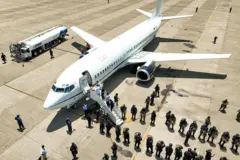 Venezuelanos detidos em El Salvador embarcam em um avião para retornar ao seu país.