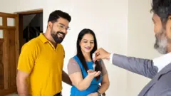 Happy young couple taking keys of their new house from broker, Real-estate agent giving keys apartment to new owners.