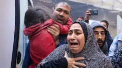 People cry as injured are being transported in an ambulance in Rafah, Gaza