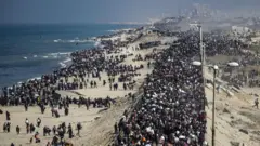 نازحون فلسطينيون خلال عودتهم من جنوبي قطاع غزة إلى شماله عبر شارع الرشيد سيراً