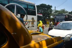 Una mujer camina por una calurosa calle en el verano de Calcuta, India. El caliente sol brilla con intensidad.