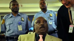 Protais Zigiranyirazo mu rukiko i Arusha ku itariki ya 18 y'ukwezi kwa cumi na kabiri mu 2008, aganira n'umwunganizi we mu mategeko